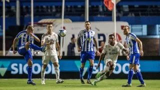 Jogadores de Avaí e Santos disputando bola no primeiro turno da Série B 2024, com torcida ao fundo