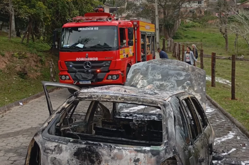 Imagem do veículo Gol G3 preto em chamas sendo atendido pelo Corpo de Bombeiros na rua Manoel José da Cunha, São José