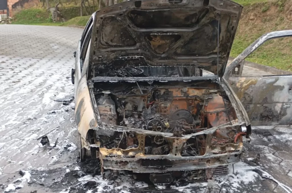 Imagem do veículo Gol G3 preto em chamas sendo atendido pelo Corpo de Bombeiros na rua Manoel José da Cunha, São José