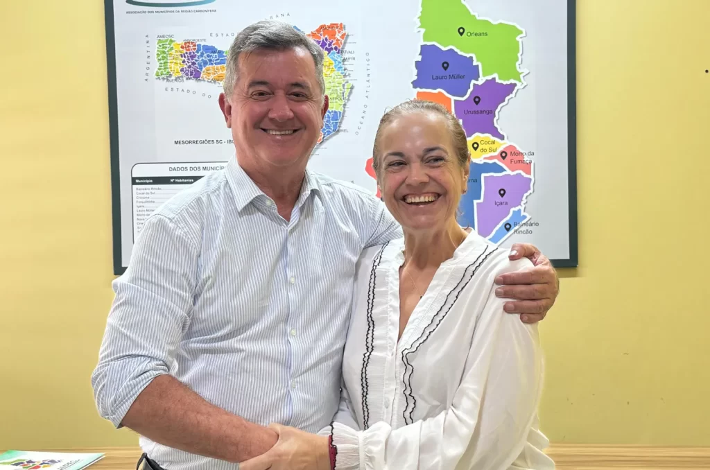 A reunião de reintegração de Criciúma à Amrec, com a presença do prefeito Ricardo Fabris e da prefeita Saionara Corrêa de Carvalho Bora, discutindo políticas públicas