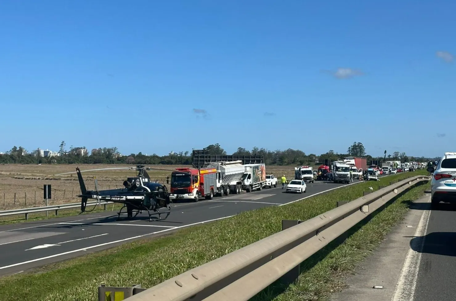 Acidente na BR-101 em Araranguá envolvendo dois caminhões e um carro de passeio, com aeronave da Polícia Civil e SAMU Aeromédico realizando resgate do motorista ferido