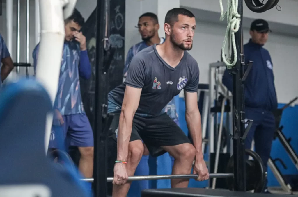 Jogadores do Caravaggio em treino físico na academia, com o preparador físico Túlio Salvaro supervisionando