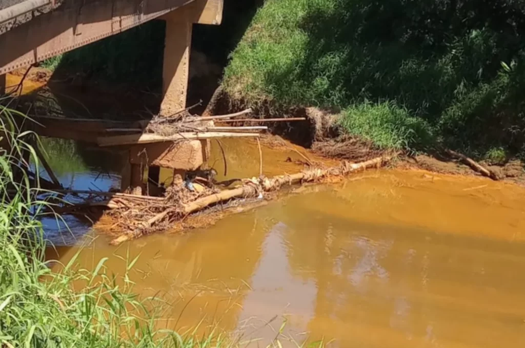 Imagem de entulhos descartados no Rio Sangão, evidenciando os desafios do desassoreamento e a necessidade de conscientização ambiental