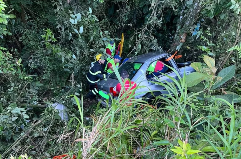 Equipes de resgate trabalham para salvar vítima de acidente em Criciúma, onde um Honda Civic caiu em uma ribanceira e colidiu com uma árvore