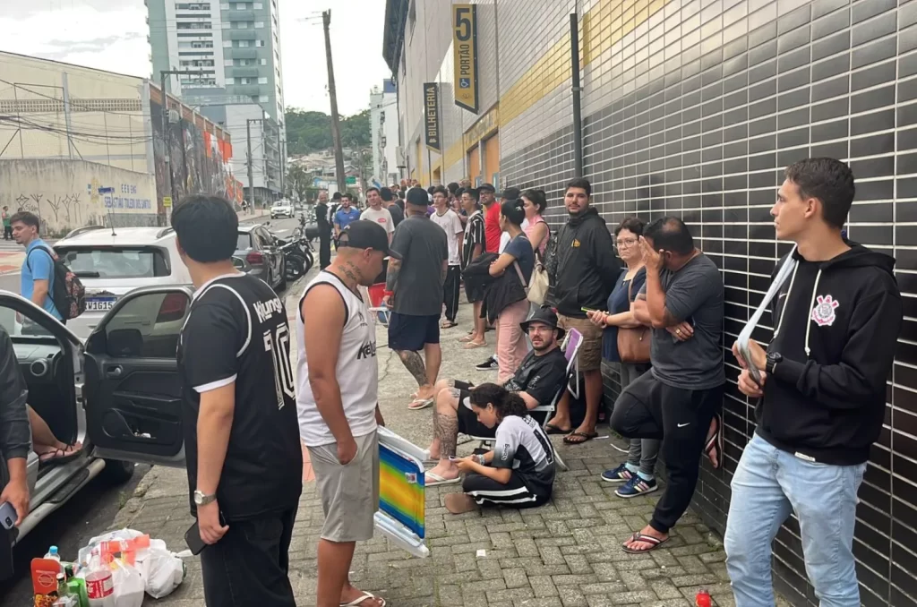 Imagem de torcedores na fila para compra de ingressos para o jogo Criciúma vs. Corinthians, com destaque para a bilheteira do clube