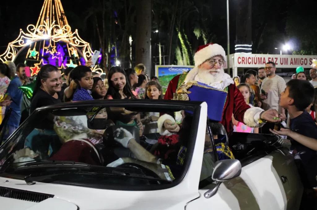 Desfile temático Ludicoz em Criciúma, com figurinos natalinos, público reunido na Rua Coronel Pedro Benedet