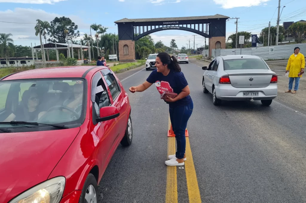 Agentes de saúde realizam pedágio de conscientização contra a dengue em Siderópolis, com panfletagem e apoio da Polícia Militar