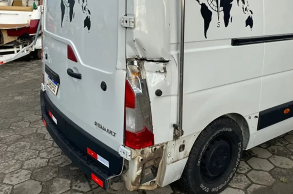 Veículo Renault Master envolvido em acidente na BR-101, próximo a prédio comercial em Araranguá