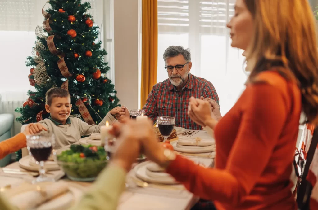 Família realizando uma oração em época de Natal