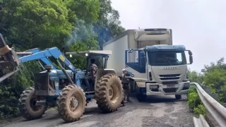 Trator trabalhando na remoção de veículo trancado na Serra do Corvo Branco