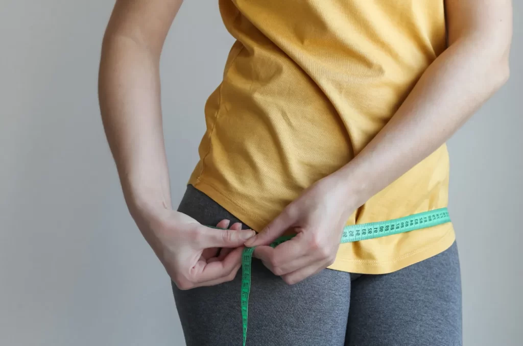 Ilustração de uma pessoa medindo a barriga após mudar o café da manhã