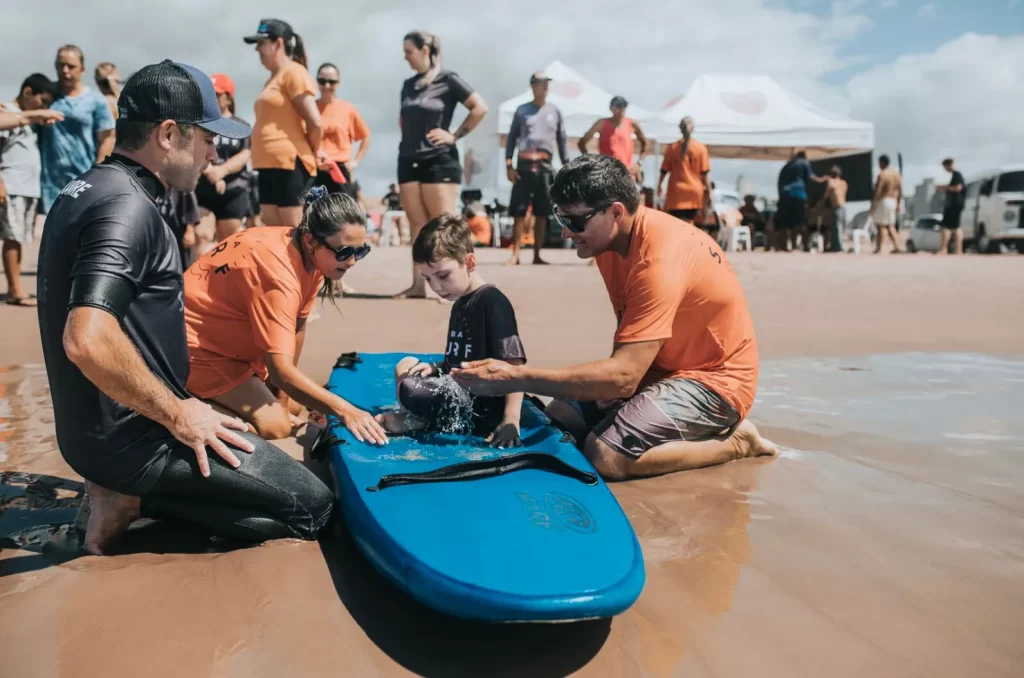 Surfistas voluntários auxiliam PCDs e autistas em evento inclusivo do projeto Abba Surf em Balneário Rincão