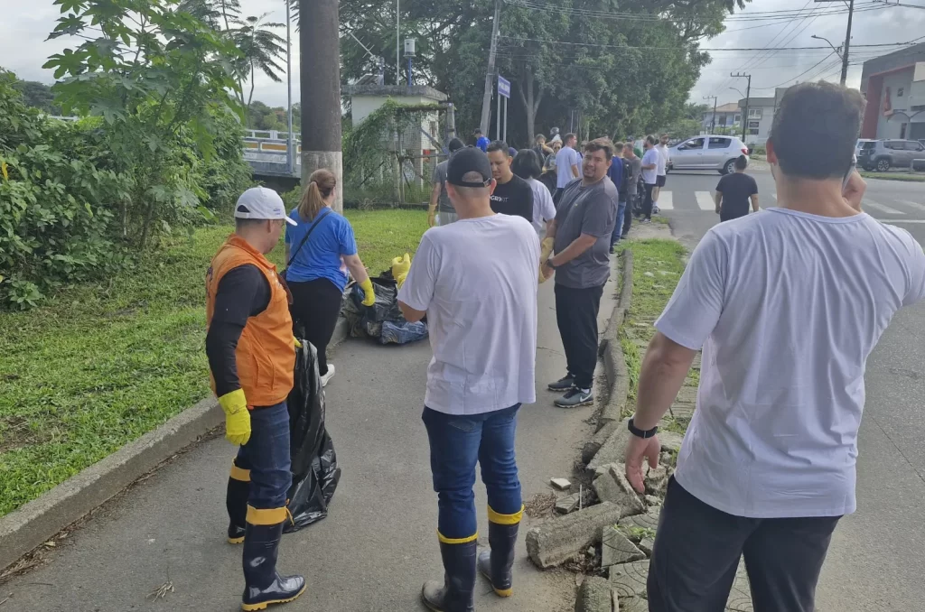 Voluntários participam do mutirão de limpeza no Rio Tubarão, promovido pela prefeitura, recolhendo lixo e revitalizando as margens