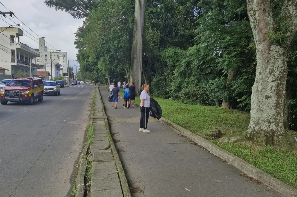 Voluntários participam do mutirão de limpeza no Rio Tubarão, promovido pela prefeitura, recolhendo lixo e revitalizando as margens