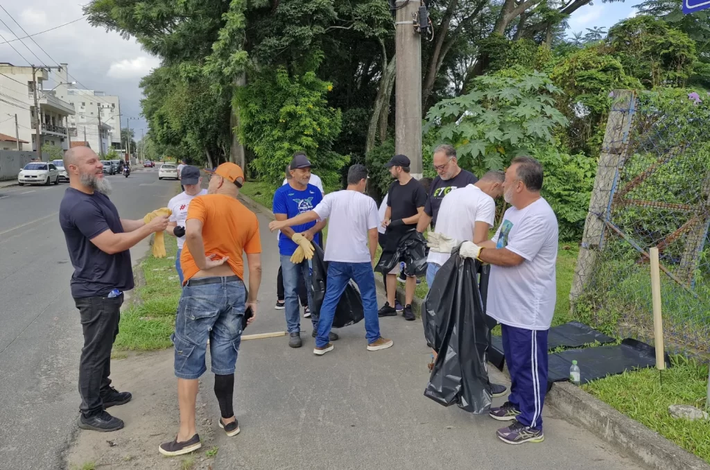 Voluntários participam do mutirão de limpeza no Rio Tubarão, promovido pela prefeitura, recolhendo lixo e revitalizando as margens