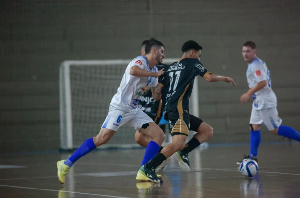 Jogadores do Criciúma Futsal e Vélez Camaquã em disputa de bola durante amistoso no Ginásio Municipal Irmão Walmir Antônio Orsi