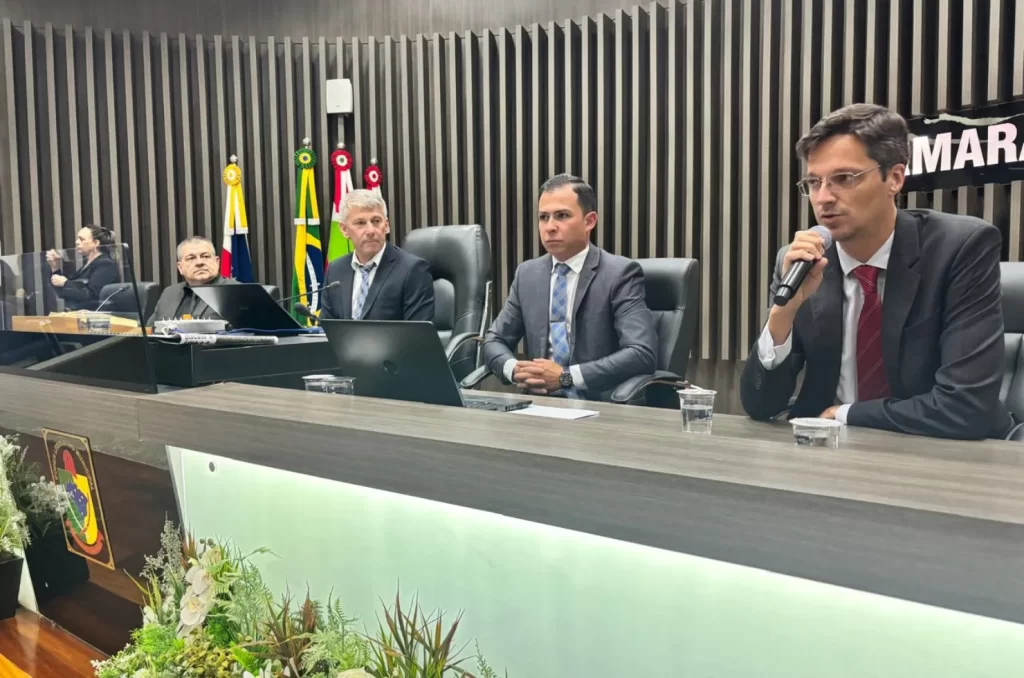 Promotor Thiago Naspolini Berenhauser fala ao microfone na Câmara de Vereadores de Araranguá sobre recuperação da Lagoa do Caverá