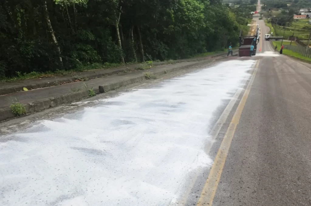 Trânsito afetado por resíduos de peixe no Morro Bonito, Criciúma, com equipes de limpeza e autoridades no local.