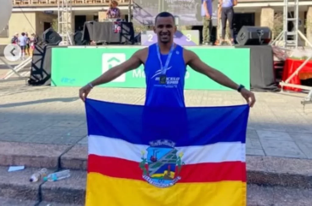 atributo alt de uma foto do atleta O ChatGPT disse: Crixtian Genuino após conquistar o 4º lugar na Maratona de Montevidéu, representando Araranguá