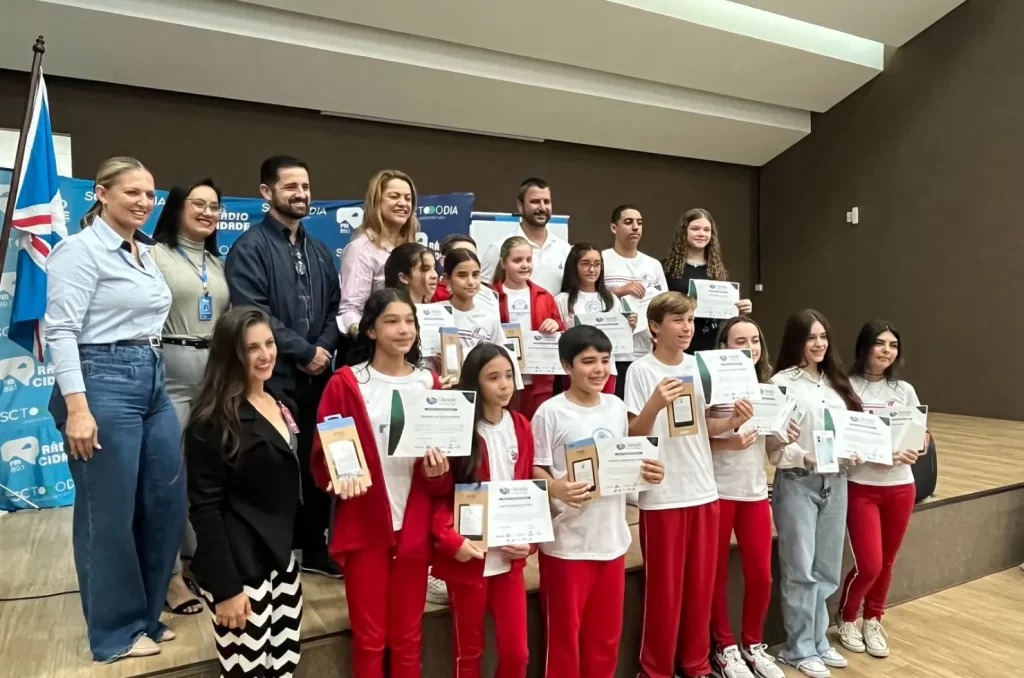Imagem da cerimônia de entrega dos prêmios aos estudantes de Içara, com a prefeita Dalvania Cardoso e a coordenadora Silvana Minato